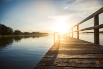 Saulės spinduliai atsispindi nuo vandens